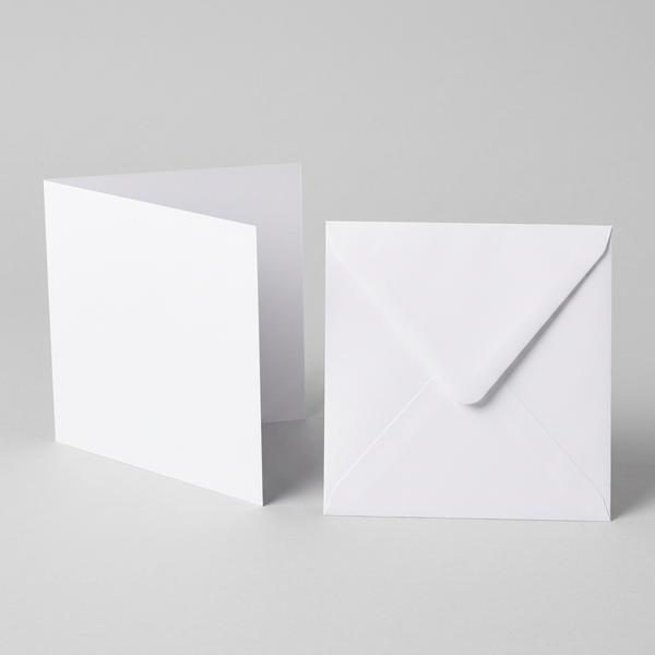 Square white 7x7 card standing open beside its envelope with the pointed diamond flap visible